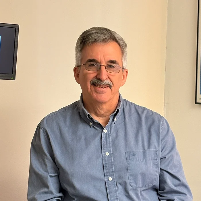 Chiropractor David Harnois Smiling In Blue Collared Shirt
